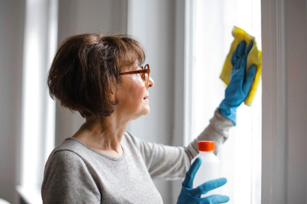 cleaning the windows with gloves and spray